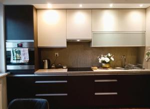 a kitchen with black and white cabinets and a sink at Apartament Ełk Tuwima 5 in Ełk