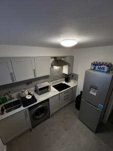 a kitchen with a sink and a refrigerator at Private Cosy Room in Barking