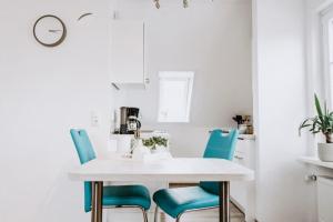 a dining room with a white table and blue chairs at Fiete in Büsum