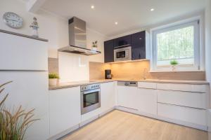 a kitchen with white cabinets and a window at Beach 4 in Rettin