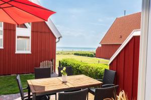 a table and chairs on a patio with a red barn at Beach 4 in Rettin