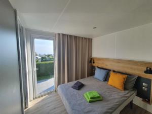 Postel nebo postele na pokoji v ubytování Campingland Ostsee - Mobilheim 111Meerblick + 15 fotografií