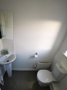 ein weißes Badezimmer mit Toilette und Waschbecken in der Unterkunft Spacious 3 Bedroom HOUSE in Dartford,London Zone 8 in Dartford