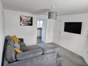 ein Wohnzimmer mit Couch und Flachbildfernseher in der Unterkunft Spacious 3 Bedroom HOUSE in Dartford,London Zone 8 in Dartford
