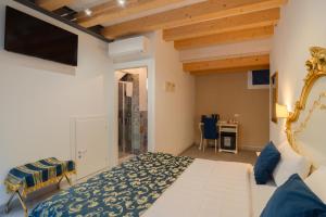 a bedroom with a bed and a tv on the wall at FloVe' Rooms Venice in Venice