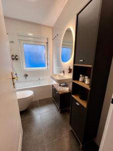 a bathroom with a sink and a tub and a toilet at MAIN Cozy Casa Universität in Würzburg +20 photos