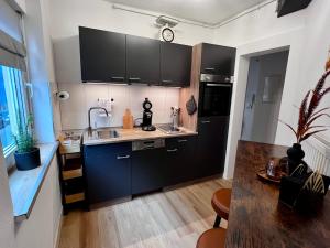a kitchen with black cabinets and a counter top at MAIN Cozy Casa Universität in Würzburg