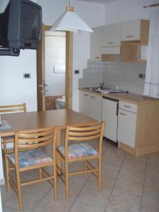 ラブラにあるFerienwohnung im Haus Texel IIIの木製のテーブルと椅子2脚のあるキッチン