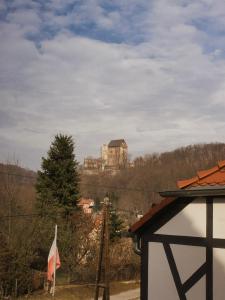 a castle on top of a hill with a flag at Gościniec Stara Mleczarnia in Bolków +21 photos
