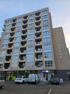 a large building with cars parked in a parking lot at Boutique apartment green 2 in Plovdiv