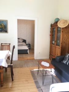 een woonkamer met een blauwe bank en een slaapkamer bij Gästehaus Schinna in Stolzenau