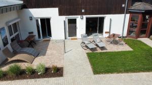 a patio with chairs and a bench in front of a building at Kastaniennest in Bingerbrück +10 photos