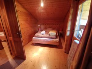 a bedroom in a log cabin with a bed in it at Chalet en bois in Bias +10 photos