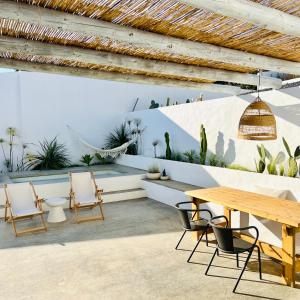 a patio with a wooden table and chairs and plants at Casa Sul - Casas de Seixe in Baiana