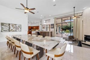 a kitchen and dining room with a large marble table and chairs at Grand 6BR Plantation Estate w Tennis POOL in Sunrise