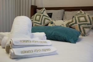 a bed with towels and pillows on it at סוויטה הילה במצובה in Maẕẕuva