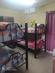 2 Etagenbetten in einem Zimmer mit lila Vorhängen in der Unterkunft Habitación con baño para 4 personas para los dias 21 y 22 in Corrientes