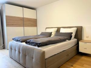 ein großes Bett in einem Zimmer mit in der Unterkunft Lüftenblick - Ferienwohnungen am Starnberger See, mit Terrasse, Weitblick, Sauna, Kamin, E-Ladestation in Berg am Starnberger See