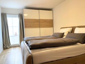 Ein Bett oder Betten in einem Zimmer der Unterkunft Lüftenblick - Ferienwohnungen am Starnberger See, mit Terrasse, Weitblick, Sauna, Kamin, E-Ladestation