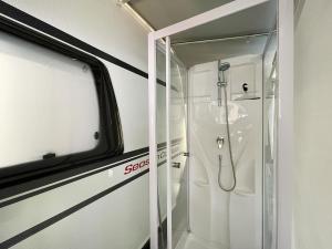 a bathroom with a shower with a glass door at Mietwohnwagen 02 in Heringsdorf