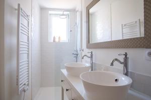 un bagno bianco con due lavandini e uno specchio di Maison Charmante au coeur de la circulade-Patio-AB a Bram Altre 14 foto