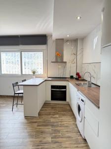 a kitchen with white cabinets and a table and a dishwasher at Casa De la Vega in Cenes de la Vega +12 photos