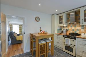 une cuisine avec un comptoir et une table à l'intérieur dans l'établissement Meadow View Cottage, à Exmouth