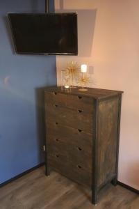 a wooden dresser with a television on top of it at BLUMENSTIL Ferienwohnungen 3 in Bad Salzungen
