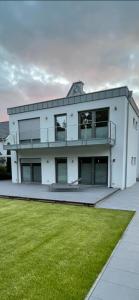 a large white building with a lawn in front of it at Kanalsuite direkt am Nord-Ostsee-Kanal in Westerrönfeld