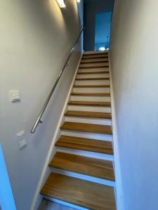 a staircase with wooden floors and a stair railing at Kanalsuite direkt am Nord-Ostsee-Kanal in Westerrönfeld +16 photos