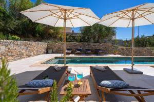 einen Pool mit 2 Stühlen und 2 Sonnenschirmen in der Unterkunft Villa Praska with private 28,5 sqm pool, 3 en-suite bedrooms, Sauna, 1km to Beach in Podstrana