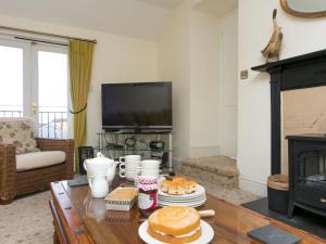 莫伊尔弗雷Tyn Lon, Moelfre, A Traditional Welsh Home By The Coast - Pass the Keys的客厅配有餐桌和食物