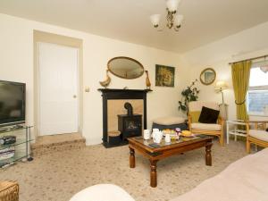 莫伊尔弗雷Tyn Lon, Moelfre, A Traditional Welsh Home By The Coast - Pass the Keys的带壁炉和桌子的客厅 更多65张照片