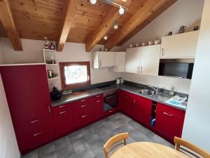 una cucina con armadi rossi e soffitto in legno di Angela a Münster