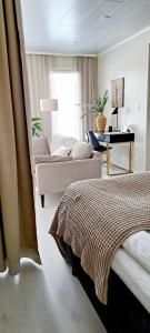 ein Schlafzimmer mit einem Bett, einer Couch und einem Schreibtisch in der Unterkunft Villa Alicia, oma 85 m2 talo, ilmastointi in Kokkola