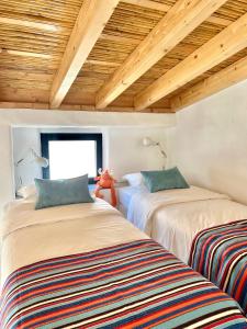 due letti in una stanza con soffitti in legno di Casa Sul - Casas de Seixe a Baiana