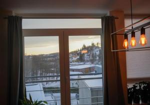 a window with a view of a snowy mountain at Solrik leilighet på Byåsen in Trondheim