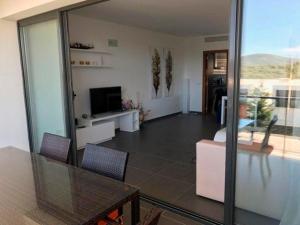 a living room with a table and a couch and a television at Luxus Chalet Casas blancas in Cala Mendia