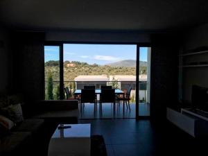a living room with a view of a table and chairs at Luxus Chalet Casas blancas in Cala Mendia