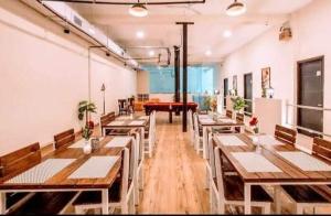 a restaurant with wooden tables and a red piano at Heistel Gurugram in Gurgaon