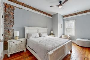 a bedroom with a white bed and a brick wall at Eagle Claw Den in Waynesville