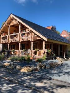 a log cabin building with a porch and balcony at Hahnenkleer Hütte Harzliebe in Goslar