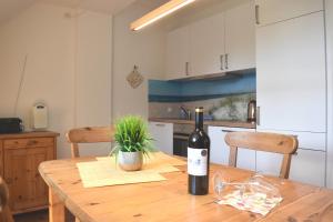 a bottle of wine on a wooden table in a kitchen at Resi E08 in Prerow
