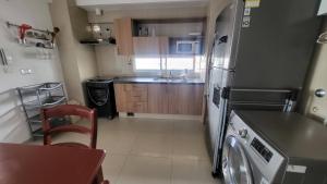 a small kitchen with a refrigerator and a dishwasher at Departamento céntrico solo para ti in Santa Cruz de la Sierra