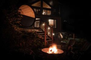 eine Feuerstelle vor einem Haus in der Nacht in der Unterkunft Windermere UK Inspired Thermal Escape SPA SAUNA in Sainte Béatrix