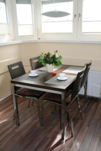 une table de salle à manger avec des chaises et un vase avec des fleurs dans l'établissement ancora Marina Haus 1 Nr 01, Typ 1, à Neustadt in Holstein