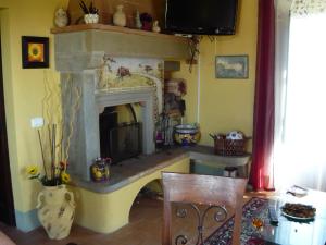 a living room with a fireplace and a table at English Garden Cortona in Cortona