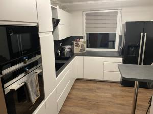 a kitchen with white cabinets and a black refrigerator at Ferienwohnung Rosa in Horn-Bad Meinberg
