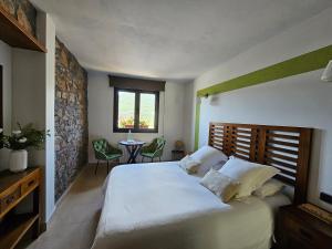 GramósLes Flors - Hotel Rural & Cabanyes的带一张大床和一张桌子的卧室