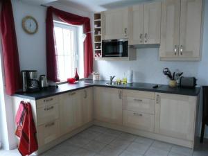 a kitchen with white cabinets and a black counter top at Ferienwohnung Böcker in Oberwiesenthal